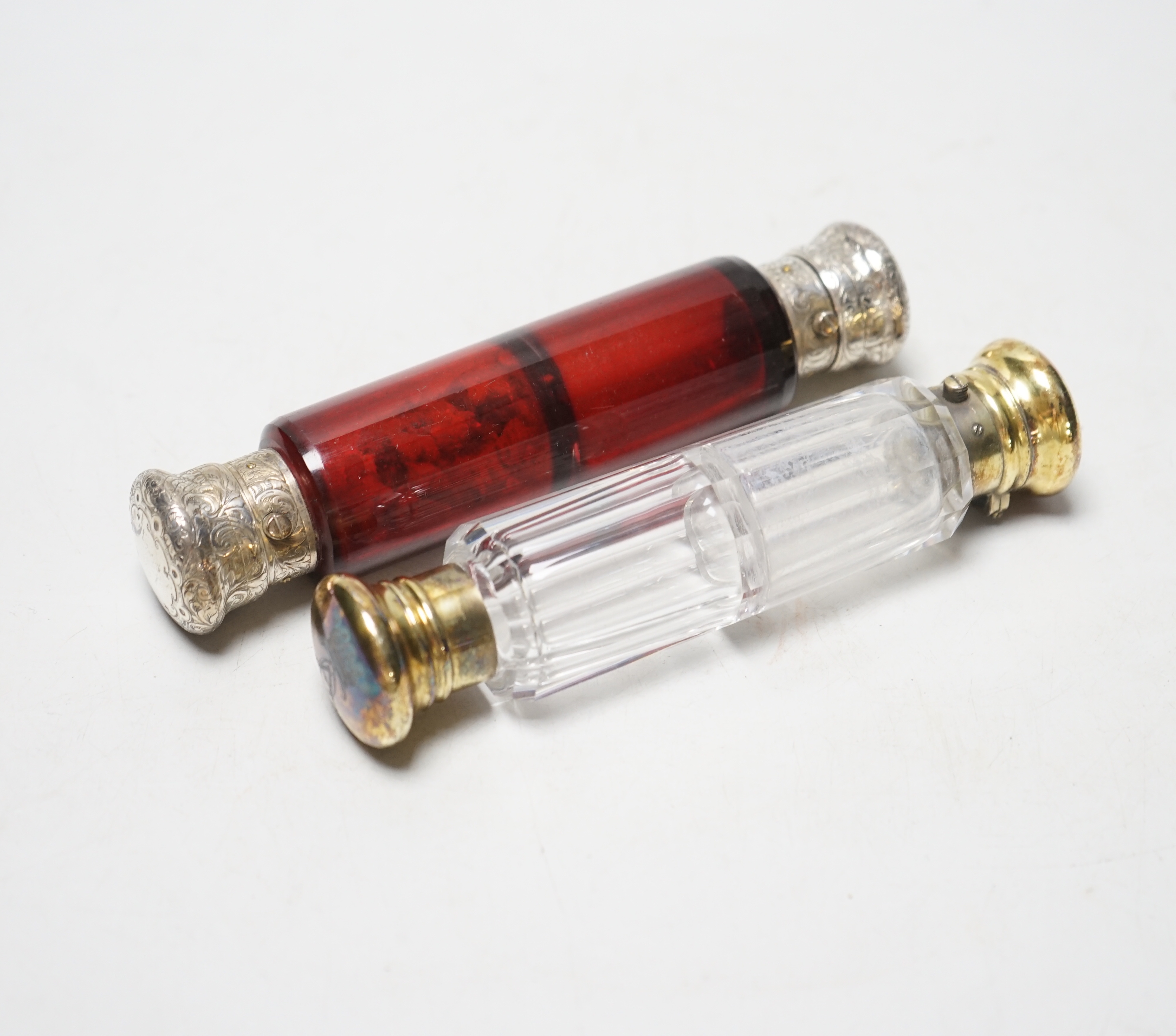 Two Victorian silver mounted glass double ended scent bottles, ruby glass, William Barker, London, 1860, 15cm and silver gilt, London, 1881.